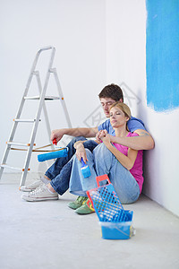在新家画完画后 快乐的年轻共唱蓝色成人妻子男性乐趣女性房间幸福财产女士图片