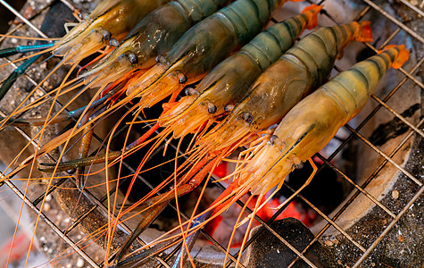 木炭烤架上的烤大虾 巨大的淡水虾在熊熊的炭火上烧烤 特写巨型河虾在烧烤架上烹饪 为聚会做饭 泰国饮食文化派对菜单甲壳动物厨房农场图片