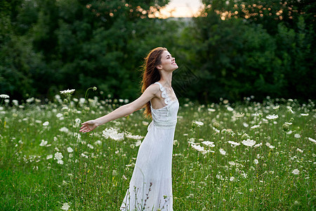 穿着白色衣服的女人 在自然界的田野里 花朵自由夏天公园裙子头发阳光帽子晴天享受女孩太阳潮人图片