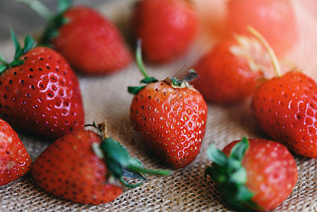 新鲜草莓在麻袋上 特写红色成熟的草莓背景图片