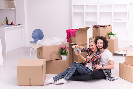 年轻夫妇搬进新房子成人地面拥抱男性幸福家庭休息公寓微笑房间图片