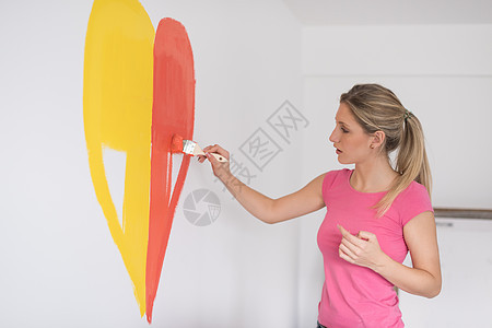 女人在墙上画一颗心女性维修工具女士微笑装潢房间风格艺术女孩图片
