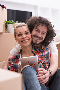年轻夫妇搬进新房子包装丈夫拥抱盒子休息男性幸福女性杯子地面图片