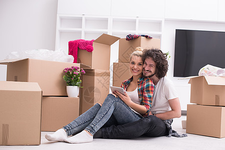 年轻夫妇搬进新房子开箱搬迁纸板休息纸盒地面包装男性家庭盒子图片
