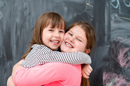 小女孩在黑板前拥抱着小姑娘孩子瞳孔学习童年神童女孩们课堂教学女性教育图片