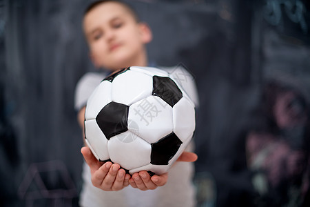 快乐的男孩在黑板前拿着足球球瞳孔孩子黑色幼儿园冒充运动童年游戏学校神童图片