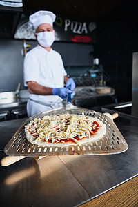 厨师用保护性冠状病毒面罩做披萨烤箱男性面包师烹饪潮人火炉食物食谱壁炉面包图片