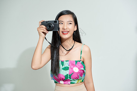 一个微笑着的年轻女性的肖像 站在影印空间上 与摄影相机站在一起 被白色背景隔绝镜片快门照片记者技术女士女孩爱好成人摄影师图片