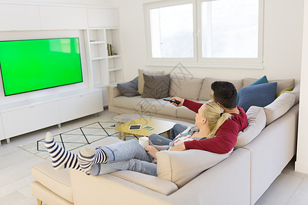 在沙发上看电视的年轻夫妇女士享受夫妻成人手表房子奢华男人家庭女性图片