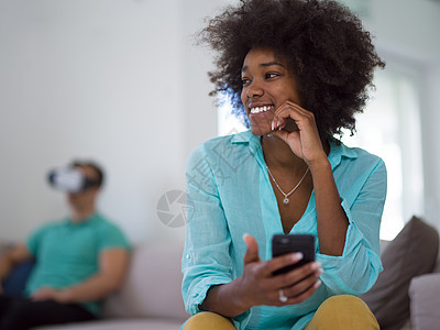 使用虚拟现实耳机的多种族夫妇模拟眼镜娱乐女士男人房间黑色虚拟现实成人沙发图片