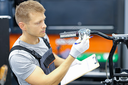 青年锁匠在服务中心对摩托车进行诊断检查以及工具机械店铺按钮车速速度行动发动机引擎控制图片