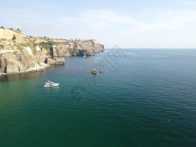 海景空中全景与水晶般清澈的蔚蓝大海和岩石海岸 在岩石背景下的美丽泻湖中的游艇 夏季旅行和度假的理想目的地的概念树木日落海洋海滩旅图片