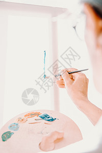 女高级老艺术家手的特写 拿着画笔 用蓝色油漆画画 五颜六色的情感油画 当代画家创作现代抽象美术作品画架工具成人工作班级学校艺术品图片