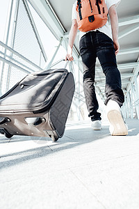 旅行期间在机场或巴士站携带行李和行李的旅客的后拍 时髦的现代旅行者 阳光明媚的日子 复制空间 广角拍摄图片