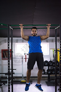 男人在水平条上拉起身体重量力量健身房抓钩运动装锻炼运动酒吧训练图片