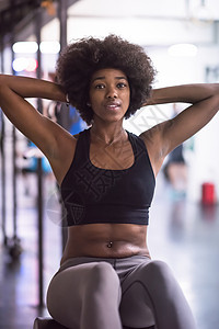 黑人女子在健身房坐着女性腹肌训练运动长椅腹部成人力量仰卧起坐运动装图片