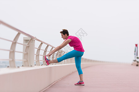 女人在赛道上伸展和升温拉伸天空身体训练时间活力运动员长廊成人锻炼图片