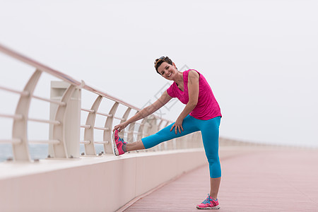 女人在赛道上伸展和升温成人天空运动员锻炼跑步海洋女性身体时间阳光图片