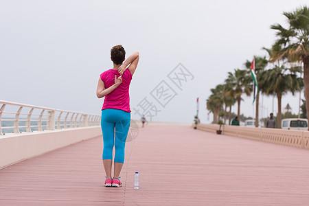 女人在赛道上伸展和升温成人训练微笑跑步拉伸海洋女士海滨女性运动图片