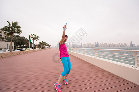 庆祝成功培训的年轻女性青年妇女人数慢跑者瓶子长廊身体跑步城市空气娱乐运动员训练图片