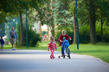 骑自行车的男童和女童朋友们孩子们快乐家庭孩子季节男生喜悦乐趣旅行图片