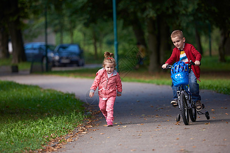 骑自行车的男童和女童旅行公园头盔孩子女士行动孩子们男生季节闲暇图片