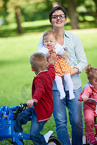 公园中快乐的年轻家庭女儿父母孩子婴儿女性妈妈童年乐趣母亲自行车图片