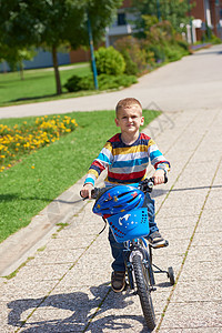 快乐的男孩 学会骑他的第一辆自行车男生安全公园乐趣头盔闲暇男性孩子孩子们骑术背景图片