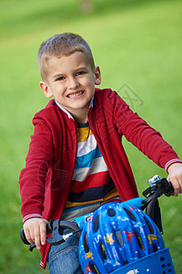 在公园骑自行车的男孩头盔跑步活动车轮男生晴天安全微笑孩子乐趣图片