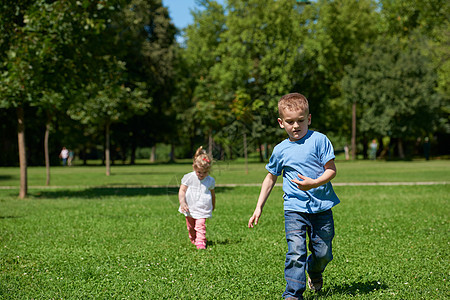 男孩女孩玩得开心 在公园里奔跑孩子们姐姐兄弟运动自由家庭女孩女孩们孩子男孩们图片