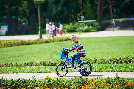 快乐的男孩 学会骑他的第一辆自行车头盔公园男性安全活动运动男生孩子们乐趣孩子图片
