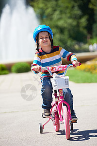 快乐的男孩 学会骑他的第一辆自行车安全孩子们男生头盔公园孩子乐趣童年活动骑术图片