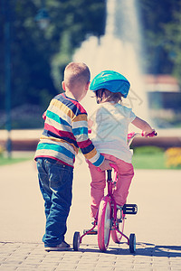 公园里的男孩和女孩 学会骑自行车孩子教学男生孩子们姐姐活动乐趣微笑童年兄弟图片