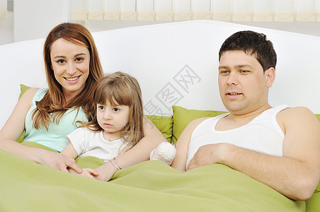幸福家庭在床上放松微笑男性房子父亲女士孩子爸爸说谎成人孩子们图片