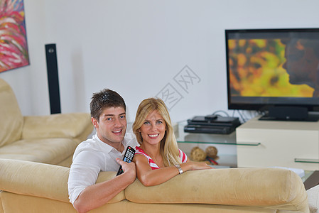 放松的年轻夫妇在家看电视房间男性娱乐成人微笑丈夫男人技术妻子享受图片
