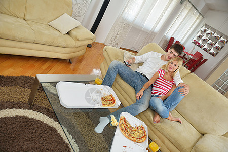 在家吃比萨饼的情侣闲暇电视食物女士朋友们微笑喜悦乐趣女性女孩图片