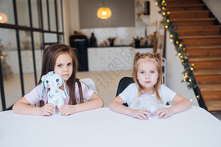 两个小妹妹一起在桌边玩耍呢孩子乐趣友谊闲暇房间女孩感情婴儿幸福玩具图片