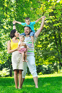 快乐的年轻夫妇和孩子 在公园玩得开心童年野餐兄弟父母母亲成人男生微笑夫妻儿子图片