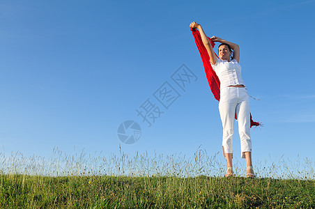 在草地上戴红色围巾的美女天空女孩微笑跑步女性自由乐趣假期成人运动图片