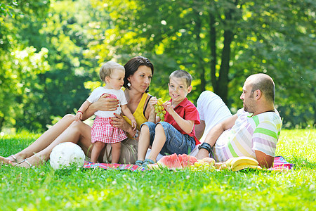 快乐的年轻夫妇和孩子 在公园玩得开心女儿夫妻女士儿子喜悦微笑父母父亲幸福孩子们图片