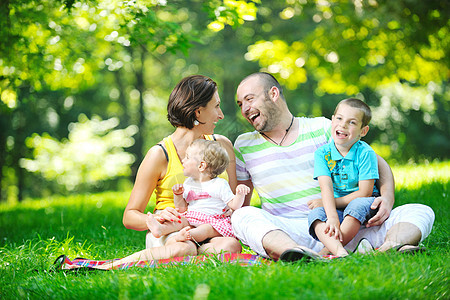 快乐的年轻夫妇和孩子 在公园玩得开心微笑男人母亲男性女儿儿子妈妈女性爸爸女孩图片