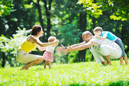 快乐的年轻夫妇和孩子 在公园玩得开心儿子野餐男人团体乐趣父母童年姐姐微笑父亲图片