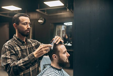 快乐的留着胡子的年轻男子在理发店被理发师理发发型服务成人治疗胡须梳子店铺顾客剪刀沙龙图片