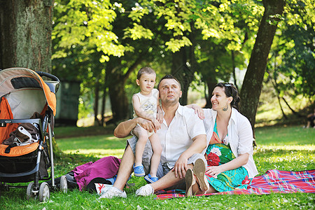 家庭在公园休息和玩乐草地幸福微笑男性父亲儿子乐趣童年野餐成人图片