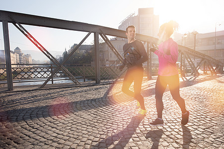 健康健康的年轻夫妇在城市中慢跑运动员夫妻成人跑步女性男人天空训练男性微笑图片