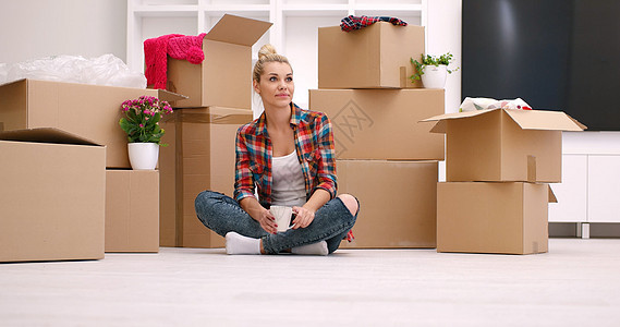 坐在地板上有许多妇女用纸板箱房间地面开箱女性包装快乐房子盒子搬迁纸板图片