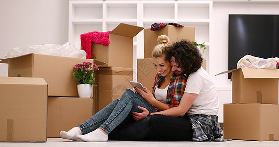 年轻夫妇搬进新房子纸板拥抱房间财产搬迁地面女士男人纸盒盒子图片
