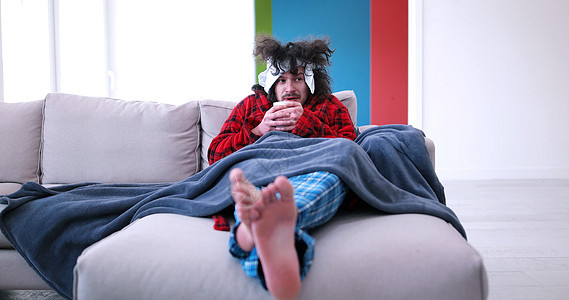 生病的人坐在沙发上 拿着杯子 坐在床上发烧房间男性诊断感染流感药品传染性症状支气管炎图片