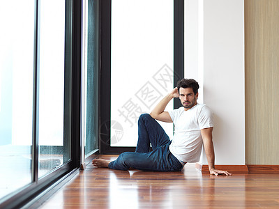 放松的青年男子喝一早咖啡木地板笔记本房间成人男性窗户白色杯子头发微笑图片