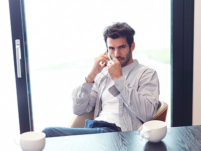 放松的青年男子喝一早咖啡地面头发杯子笔记本电话男人窗户木地板白色电脑图片